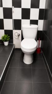a bathroom with a toilet in a black and white checkered wall at පසන් නිවස Pasan Niwasa Homestay Bandarawela in Bandarawela +8 photos