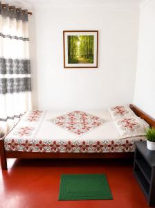 a bed in a room with a green rug at පසන් නිවස Pasan Niwasa Homestay Bandarawela in Bandarawela