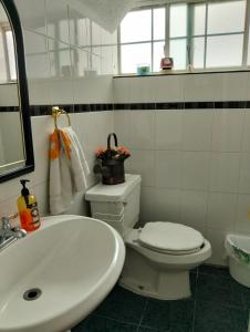a bathroom with a white toilet and a sink at House in a private gated community in Chihuahua