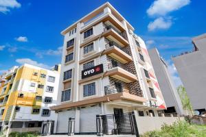 an apartment building with an open sign on it at Hotel O by OYO Eco Greenway Retreat in Salua +20 photos