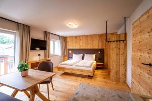 a bedroom with a bed and a wooden wall at DORFSTUDIO Apartments in Söll