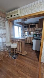 a kitchen with a counter and stools in a room at Квартира1 in Balqash