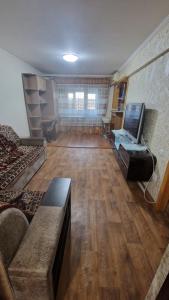 a large living room with a couch and a tv at Квартира1 in Balqash