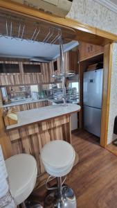 a kitchen with two white stools and a counter at Квартира1 in Balqash