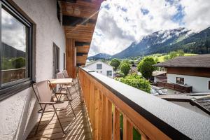 a balcony with chairs and a view of mountains at DORFSTUDIO Apartments in Söll