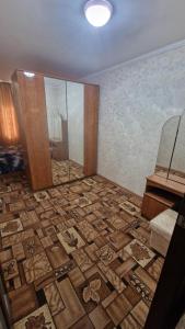 a room with a large tile floor with a mirror at Квартира1 in Balqash