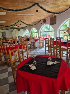 a dining room with tables and chairs with red table cloth at Camping Las Torcacitas in Yerbas Buenas