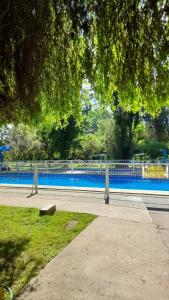 a park with a fence and a bench next to a pool at Camping Las Torcacitas in Yerbas Buenas