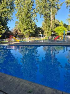 a bridge over a swimming pool in a park at Camping Las Torcacitas in Yerbas Buenas +6 photos