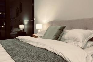 a bedroom with a bed with white sheets and pillows at The Rush in Campbell