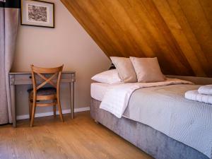 a bedroom with a bed and a desk with a chair at Bugiem i Miodem in Siemiatycze