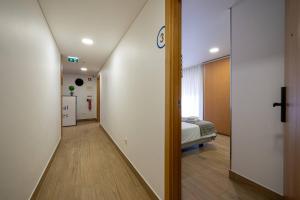 a hallway of a hospital with a bed in a room at Central Suítes 3 in São João da Madeira