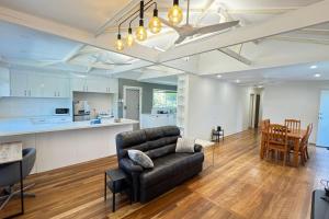 a living room and kitchen with a couch and a table at Pool house for BIG Groups with Free parking in Marsden