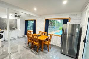 a kitchen with a table and chairs and a refrigerator at Pool house for BIG Groups with Free parking in Marsden