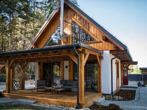 a timber frame house with a large open deck at Bugiem i Miodem in Siemiatycze