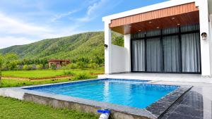 a swimming pool in front of a house at Kaya Nature Resort in Ajabgarh