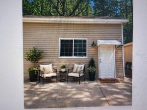 a patio with two chairs and a table and a building at Nest in the City in Fort Mill