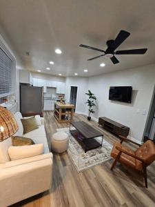 a living room with a couch and a ceiling fan at Nest in the City in Fort Mill