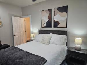 a bedroom with a bed and two paintings on the wall at Nest in the City in Fort Mill