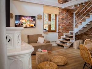 a living room with a couch and a staircase at Bugiem i Miodem in Siemiatycze