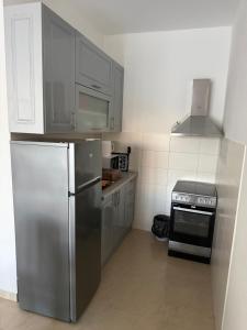 a kitchen with a stainless steel refrigerator and a stove at Studio apartman Budex in Đenovići