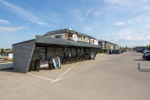 a building with bikes parked in a parking lot at MB Apartments z Basenem i Ogrodem in Sarbinowo