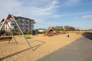 an empty playground in front of a building at MB Apartments z Basenem i Ogrodem in Sarbinowo