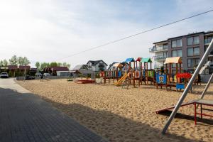 a playground on a beach with a building at MB Apartments z Basenem i Ogrodem in Sarbinowo