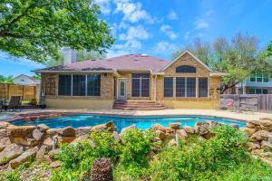 a home with a swimming pool in front of a house at 3BR home with private pool 3 mins 2 Riverplace in Austin