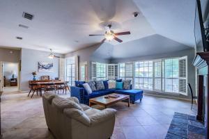 a living room with a blue couch and a ceiling fan at 3BR home with private pool 3 mins 2 Riverplace in Austin