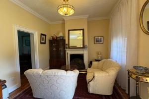 a living room with two chairs and a fireplace at Oscar's Place in Yass
