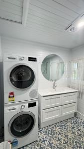 a laundry room with a washing machine and a sink at Oscar's Place in Yass