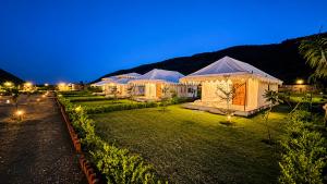 a row of tents in a yard at night at Kaya Nature Resort in Ajabgarh