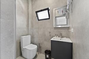 a bathroom with a toilet and a sink and a mirror at Casa Del Sol Seaside Hotel in Durrës +38 photos