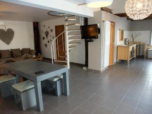 Port-sur-SaôneにあるLa petite maison de Marieのテーブルとテレビのあるリビングルーム