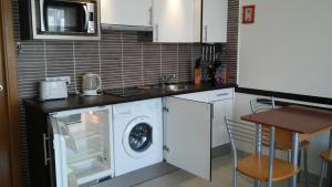 a kitchen with a washing machine and a sink at Los Hibiscos 406 in Costa Calma
