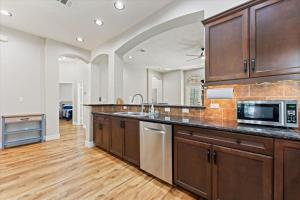 a large kitchen with wooden cabinets and a microwave at Pines and Patio Hideaway in Conroe