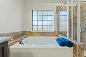 a bath tub in a bathroom with a window at Pines and Patio Hideaway in Conroe +35 photos