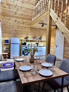 a wooden dining room with a table and a kitchen at Tengri House A-Frame Issyk-Kul in Kaji-Say +23 photos