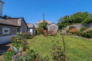 a garden with a table and chairs in the yard at Cove Cottage in Tintagel
