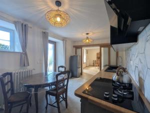 a kitchen with a table and a kitchen with a stove at Gîte le saint goth in Bricon
