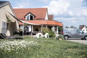 a van parked in front of a house with white chairs at Landhaus Hohenlohe in Rot am See