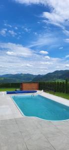 a swimming pool with a view of the mountains at Chatki Niwki u Zbója in Krościenko