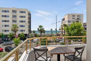 a balcony with a table and chairs and a view of a city at Casa Del Sol Seaside Hotel in Durrës