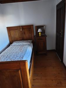 a bedroom with a wooden bed and a lamp on a table at La Casa nel Sole in Savogna