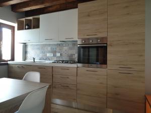 a kitchen with wooden cabinets and a stove top oven at La Casa nel Sole in Savogna
