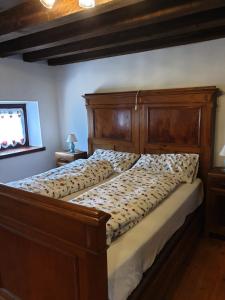 a bed with a wooden headboard in a bedroom at La Casa nel Sole in Savogna +7 photos