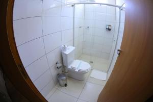 a white bathroom with a toilet and a shower at Paraná Comfort Hotel in Cianorte