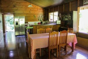 a kitchen with a table and chairs and a refrigerator at Quinta La Carmencita in Santa Elena