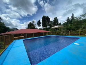 a large blue swimming pool in front of a building at Quinta La Carmencita in Santa Elena +18 photos